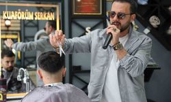 Bir elinde makas diğer elinde mikrofon