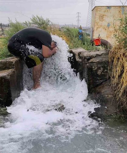 Kavurucu sıcakta elbisesini bile çıkarmadan buz gibi sondaj suyunda serinledi