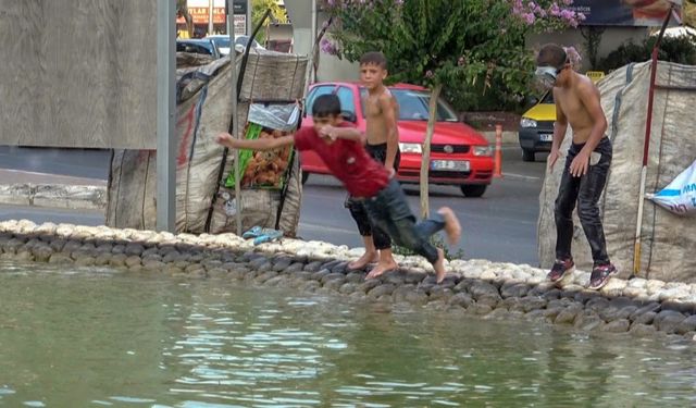 Antalya’da sıcaktan bunalan hurdacı çocuklar deniz gözlüklerini takıp soluğu süs havuzunda aldı