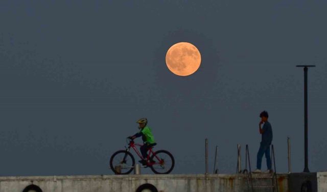 Dolunay ile insanların siluetleri aynı karede