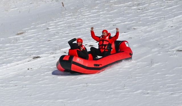 Karla kaplı dağdan donmuş gölete botla kaydılar