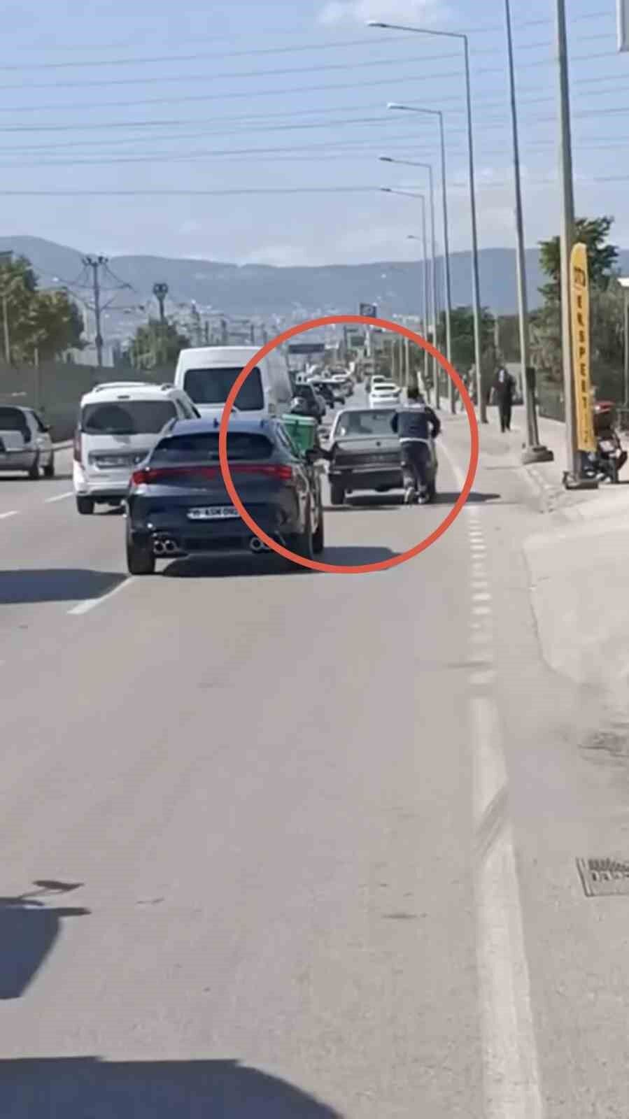 Bursa'da motokuryeden arızalanan otomobili itmek için ilginç yöntem
